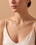 Velvet Shine Necklace, gold-tone clover pendant worn on model | Velvet Shine ketting, goudkleurige klaverhanger gedragen door model