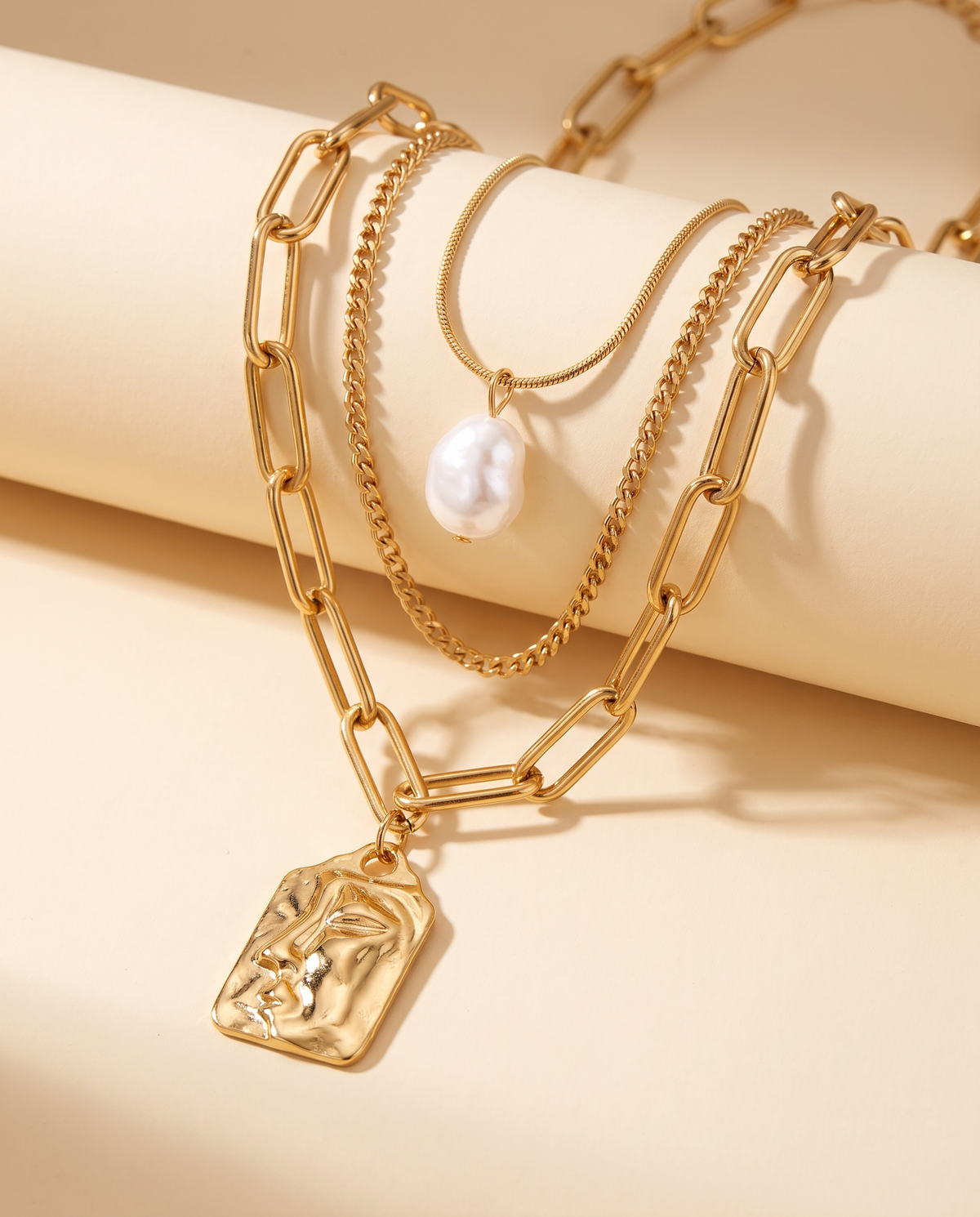 Golden Wave Set, close-up of face pendant and pearl-style accent | Golden Wave set, close-up van gezichtshanger en parelachtig accent