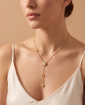 Radiant Day Necklace, gold-tone Y-necklace with side disc, crystal pendant, open ring and crystal drop worn on model | Radiant Day ketting, goudkleurige Y-ketting met schijfje, kristalhanger, open ringetje en kristal gedragen door model